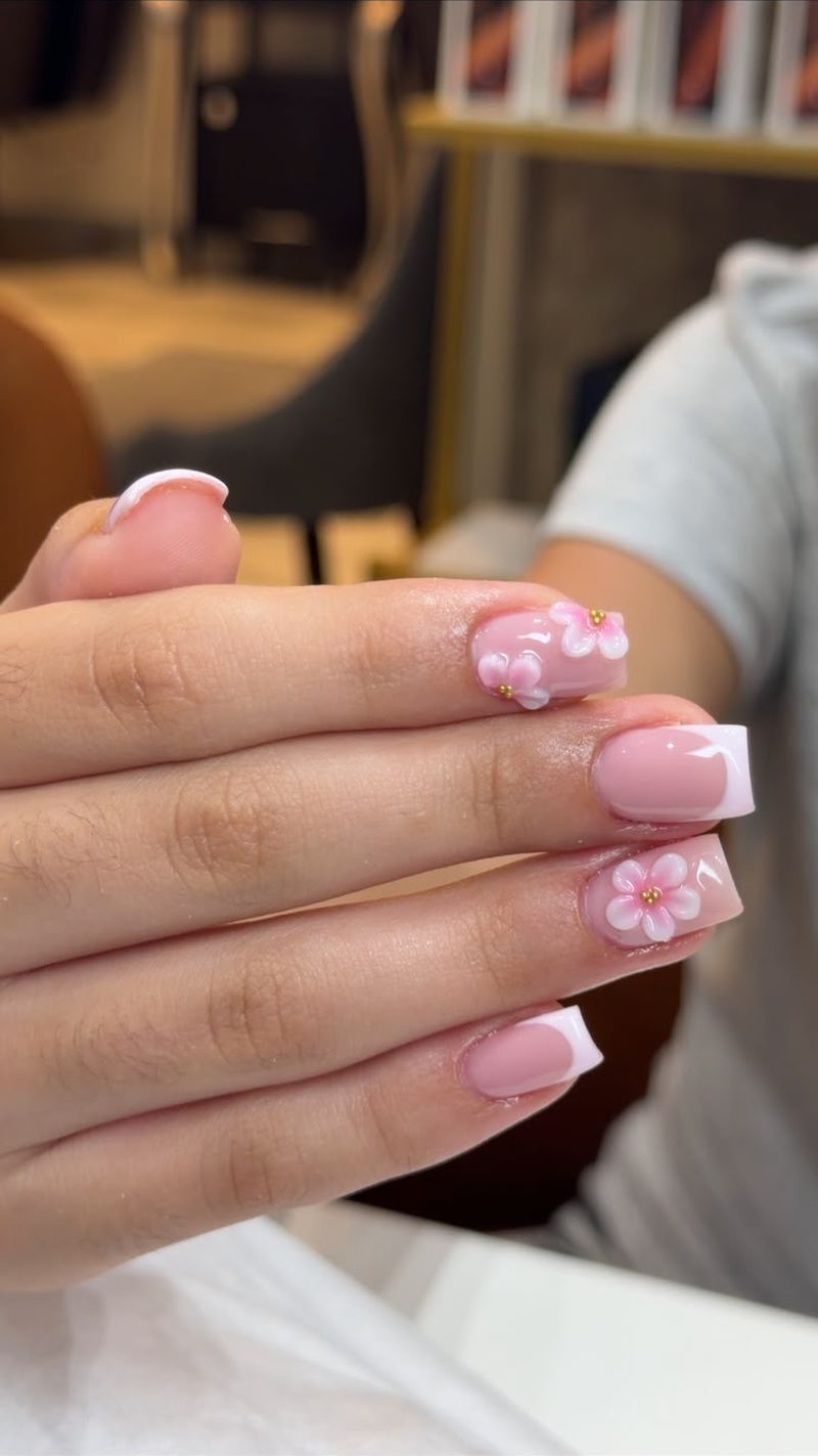 Ongles courts roses avec fleurs blanches en relief